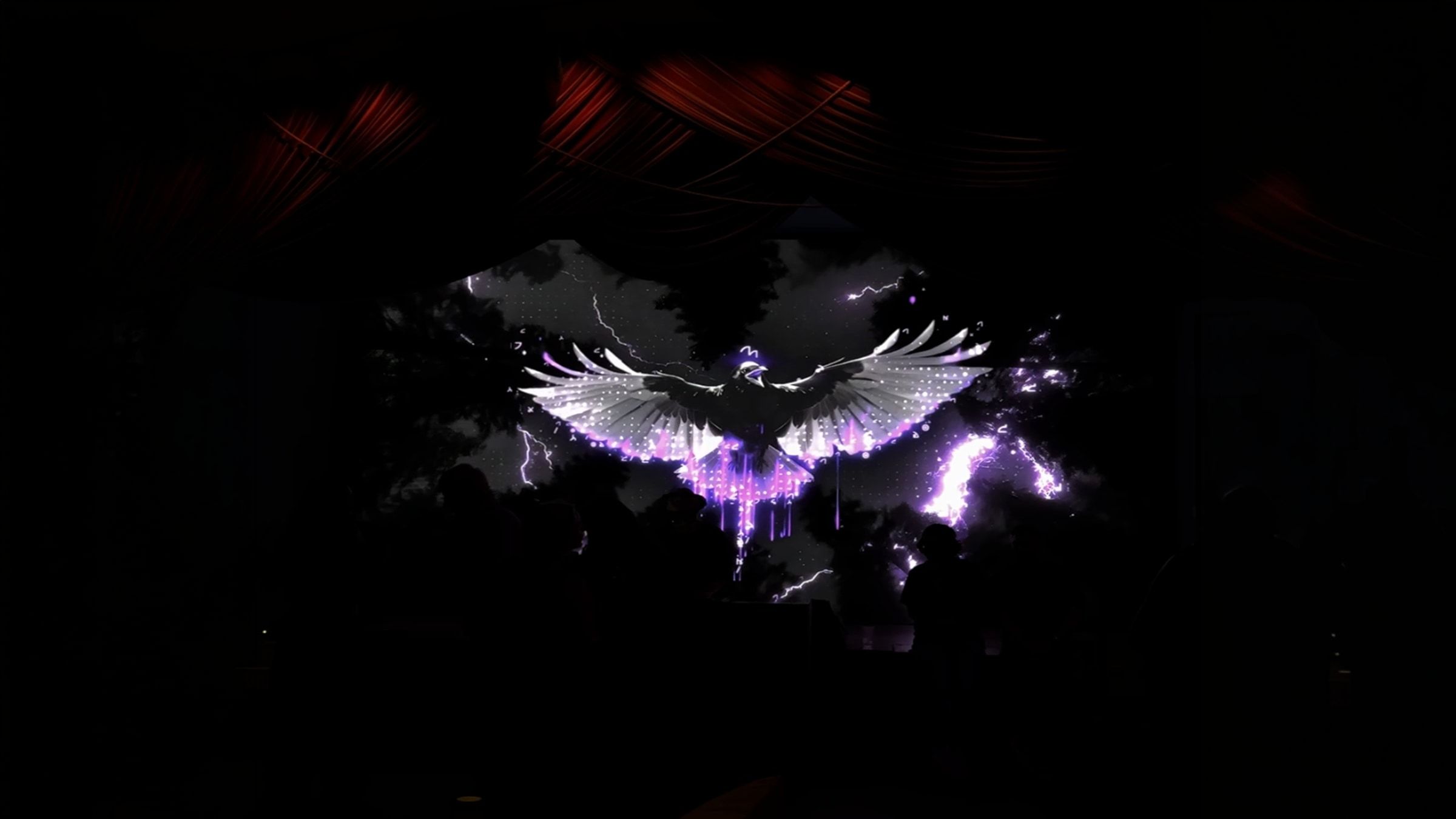 The LED wall in a darker moment, showing the bird with purple streaks.